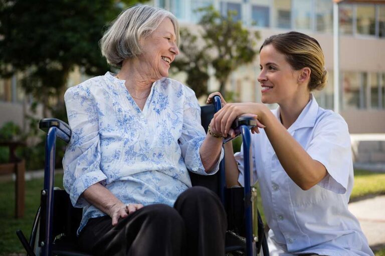 Family members compare assisted living brochures and notes at a kitchen table.