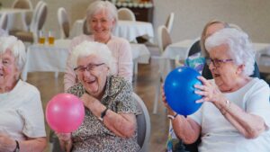 Family member sits beside an assisted living resident with a hospice nurse reviewing a comfort-care plan.